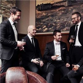 Five men in black suits drinking wine